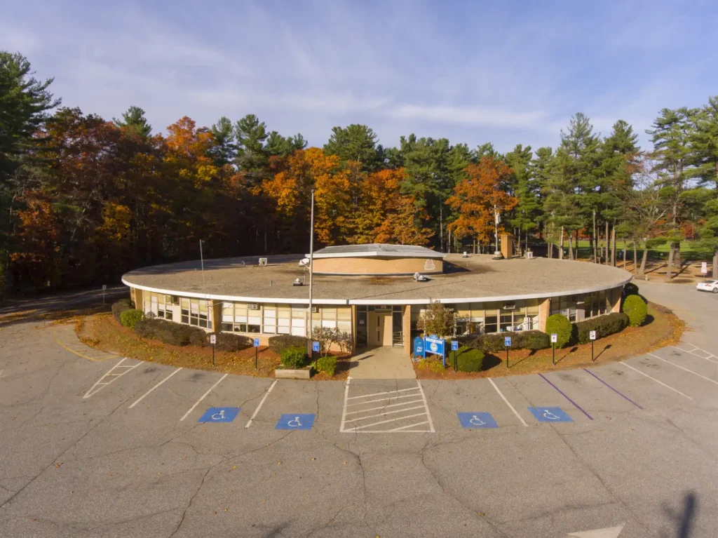 Aerial View of Circular Mid Century Town Hall Building with Parking Lot in Autumn.jpg